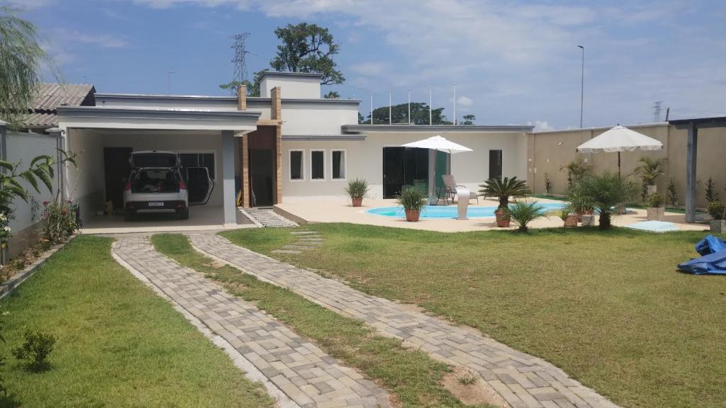 a house with a car parked in the driveway at Chacara Urbana in Navegantes