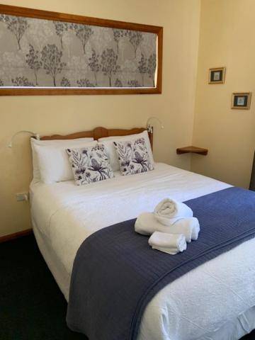 a hotel room with a bed with towels on it at Whiskey Gully Cottages in Stanthorpe
