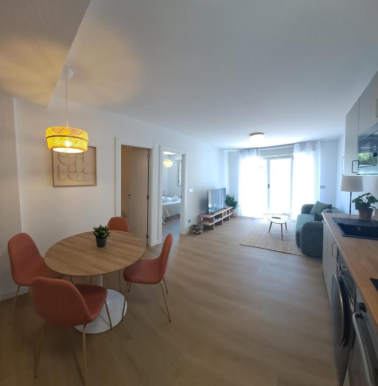 a kitchen and a living room with a table and chairs at Costa Canido I in Malpica