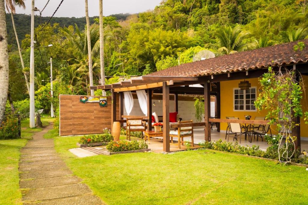 a house with a table and chairs in a yard at Pousada Gata Russa in Saco do Ceu
