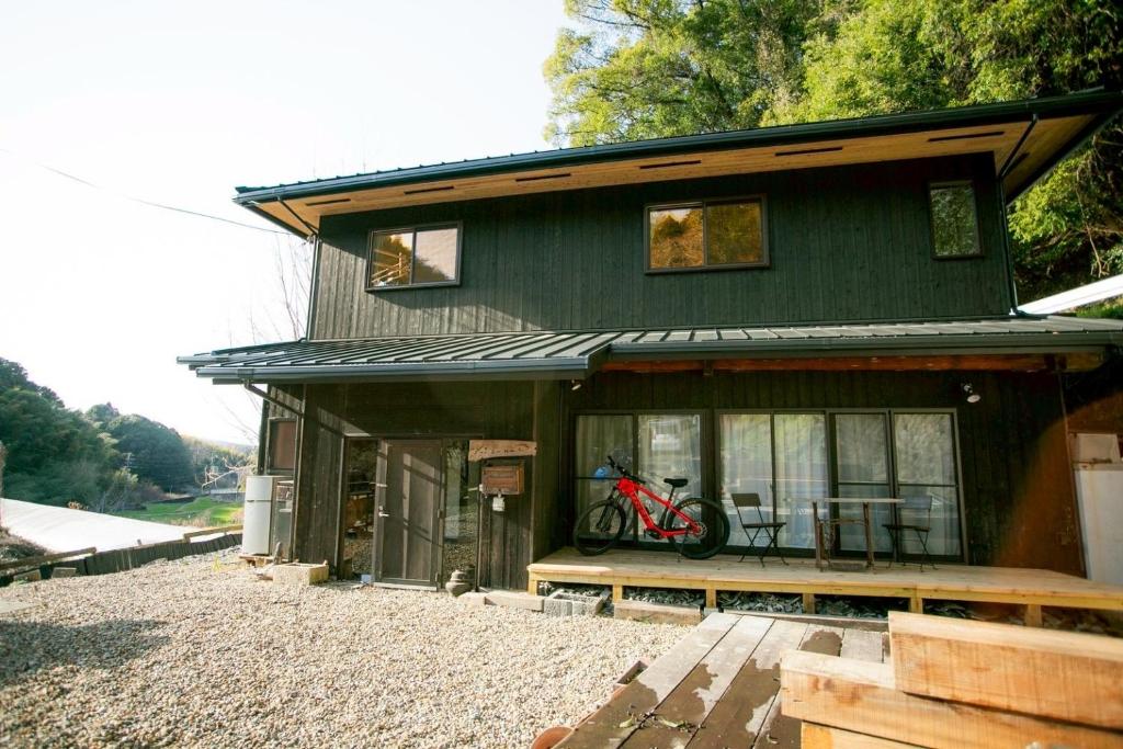 a house with a bike parked outside of it at Kizuna Guesthouse in Kizugawa