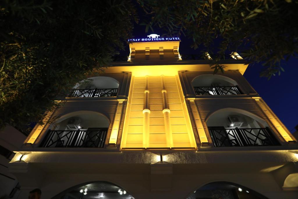 a yellow building with a balcony at night at Italy hotel in Silifke
