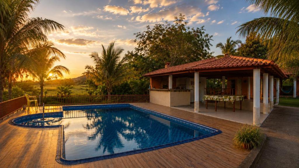 a swimming pool in front of a house with a gazebo at Pousada Serra Dourada Mossâmedes in Mossâmedes