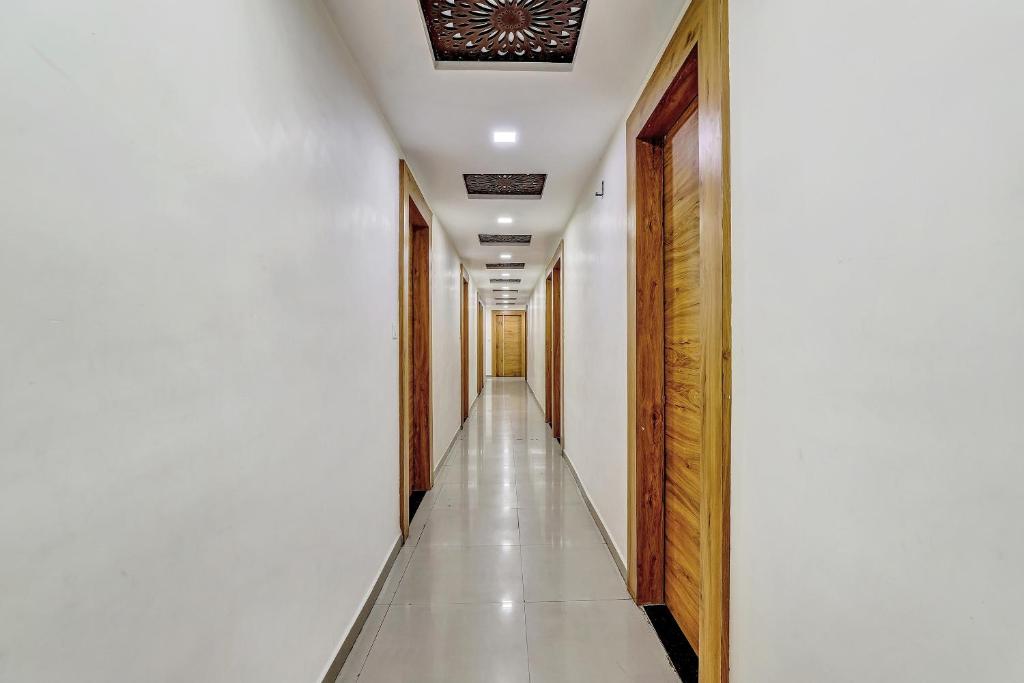 a corridor with white walls and a ceiling at Hotel O Maple view in Naroda