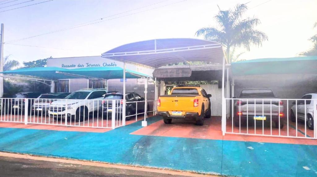 a car dealership with cars parked in a parking lot at Recanto das Termas, Chalés in Termas do Ibirá