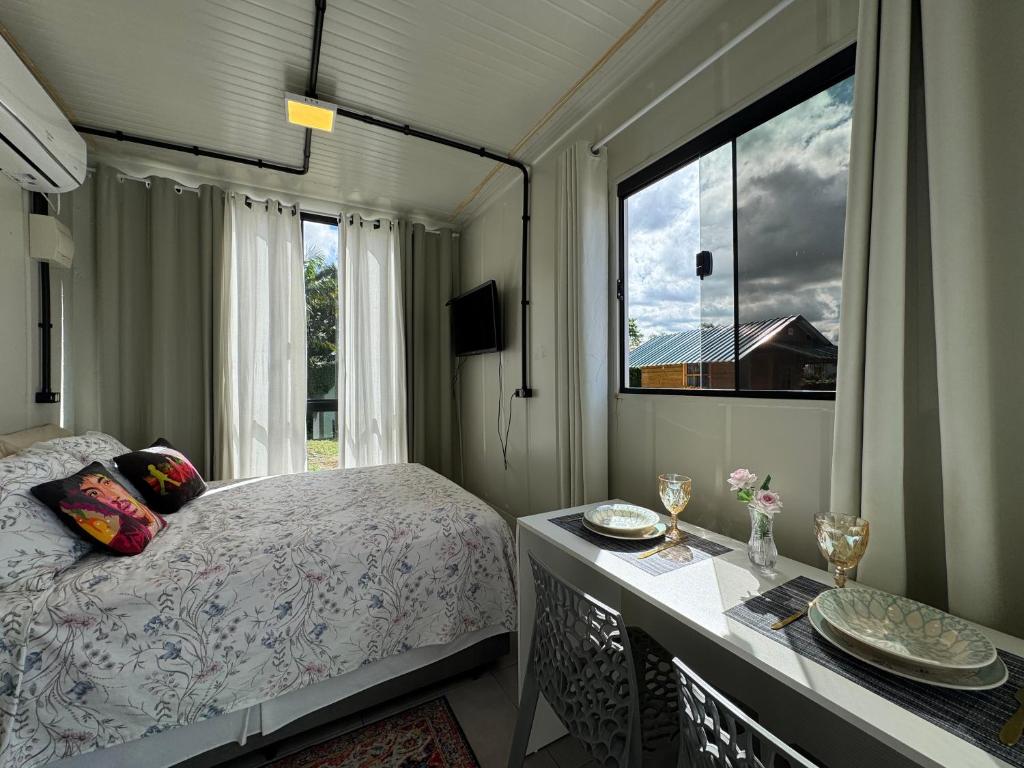 a bedroom with a bed and a large window at Charmoso e bem localizado! in Tijucas