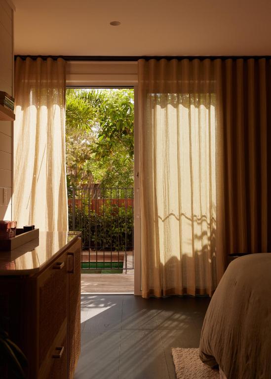 a bedroom with a bed and a sliding glass door at 28 Degrees Byron Bay - Adults Only in Byron Bay