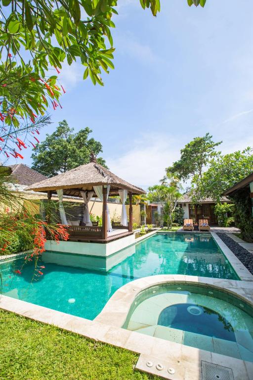 a swimming pool in a yard with a gazebo at Villa Seriska Satu Sanur,a Luxury 4-Bedroom Villa, 5 mins walk to ICON Mall, Beach & 24hrs Security in Sanur