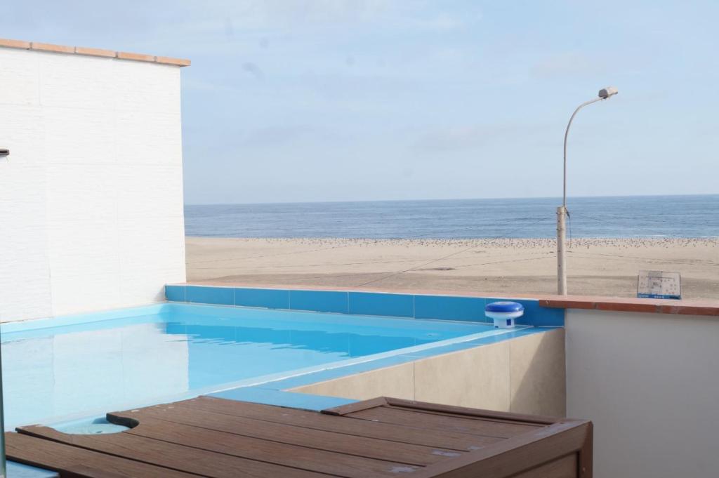 a swimming pool with a view of the beach at Ohana's Beach House in Punta Negra