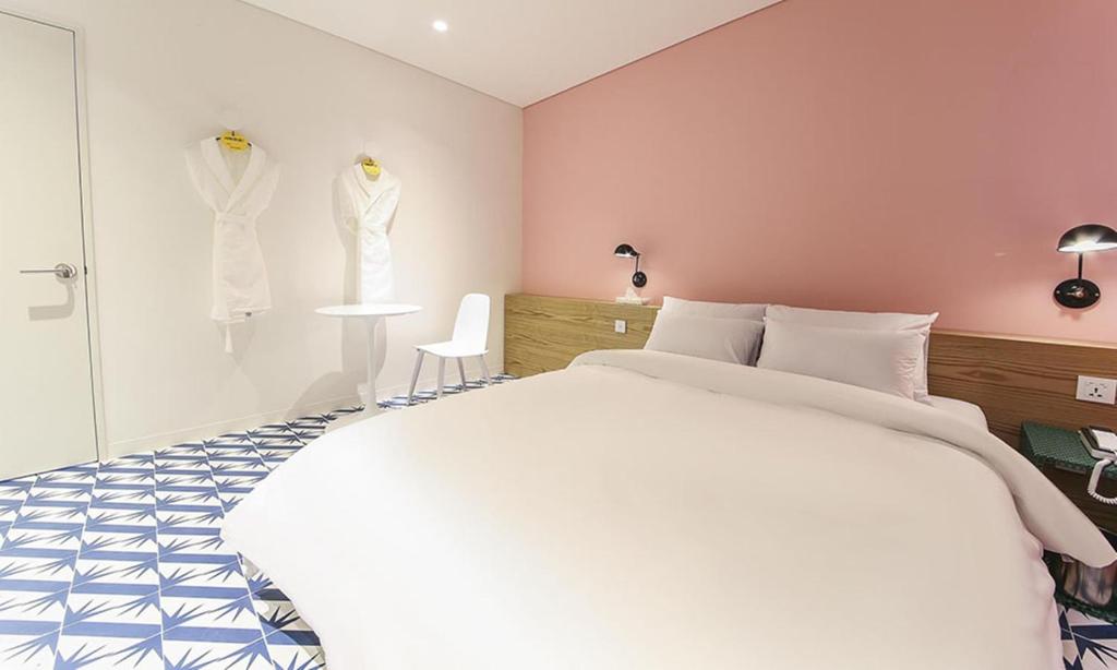 a bedroom with a white bed and two mannequins at Hotel Yeogiuhtte Chungjangro in Gwangju
