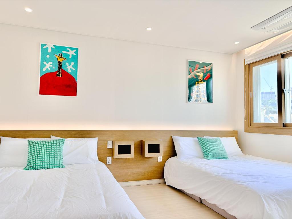 two beds sitting next to each other in a room at Fine On Stay Jeonpo in Busan