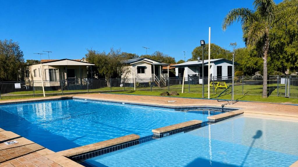 a large swimming pool in a yard with houses at At Busso Cabin 56 in Broadwater