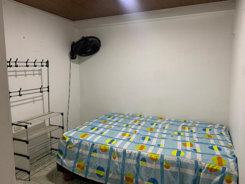 a bedroom with a bed and a white wall at Marthita House in Puerto López