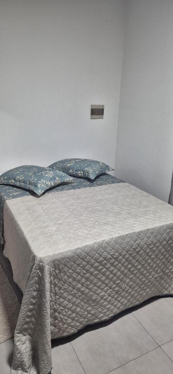 a bed in a white room with at Studio Central in Campo Grande
