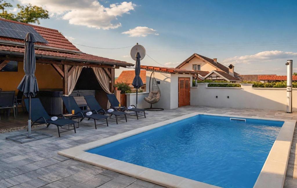 a swimming pool in a backyard with chairs and umbrellas at Stunning Home In Kutina With Sauna in Kutina
