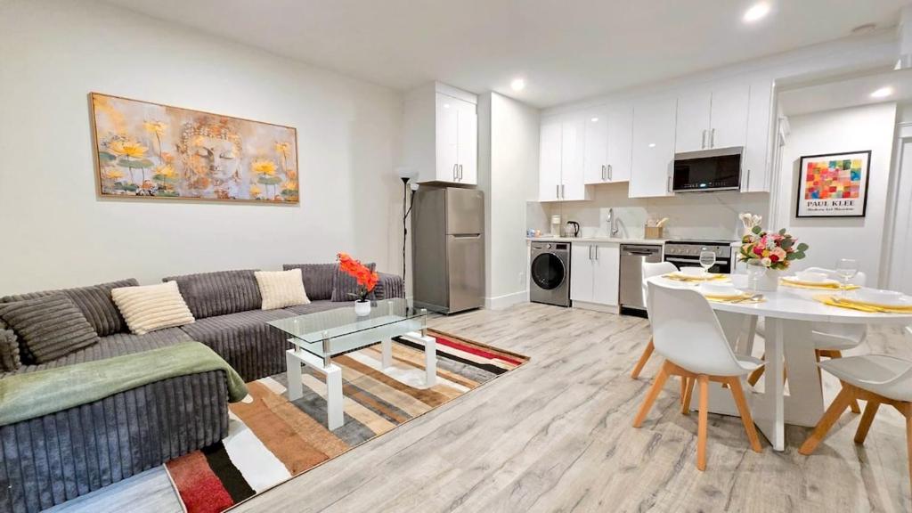 a living room with a couch and a table at Mountain Views, Premium Coquitlam Stay, Minutes to Transit in Coquitlam