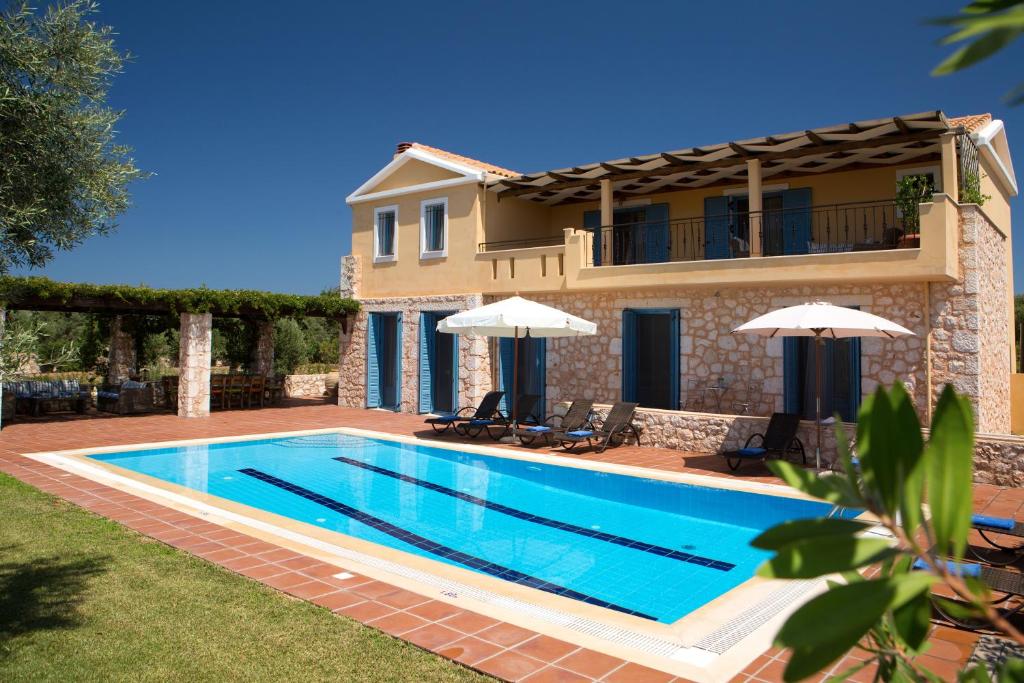 a swimming pool in front of a house at Villas Armeno - Maria in Sivota