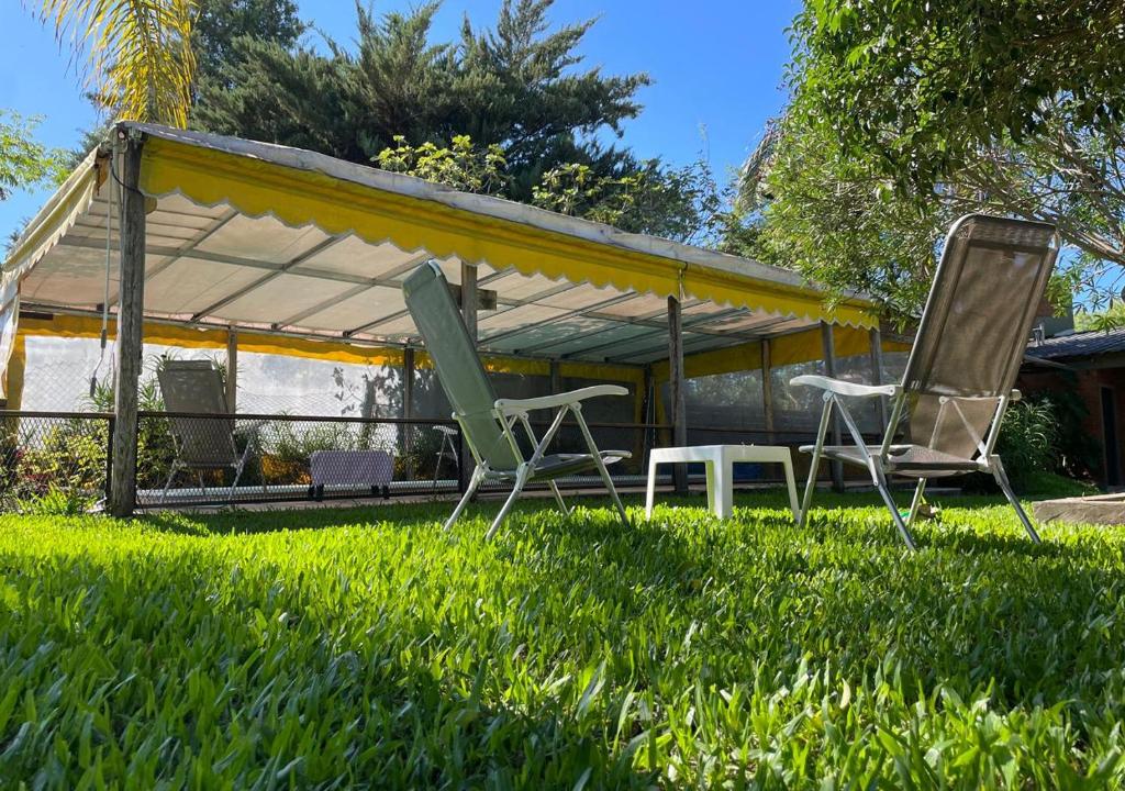 two chairs and a tent in the grass at El Cantaro in Villa Elisa