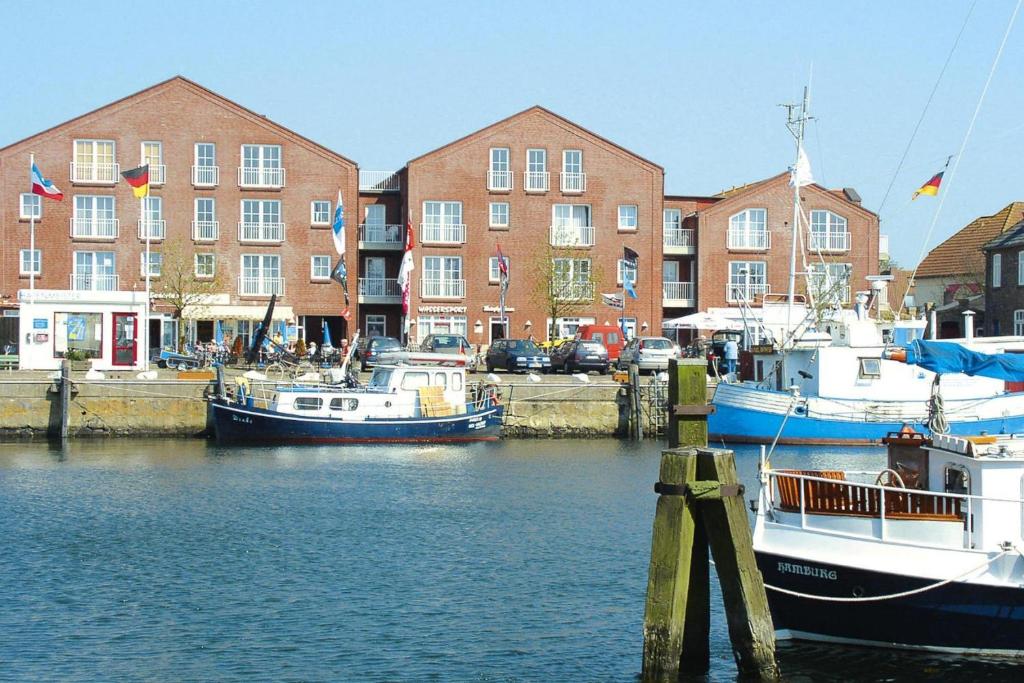 three boats are docked in a marina with buildings at Ferienwohnung auf Fehmarn in Orther Reede in Orth