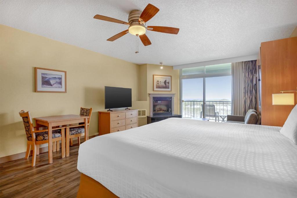 a bedroom with a large bed with a ceiling fan at Best Western Plus Ocean View Resort in Seaside