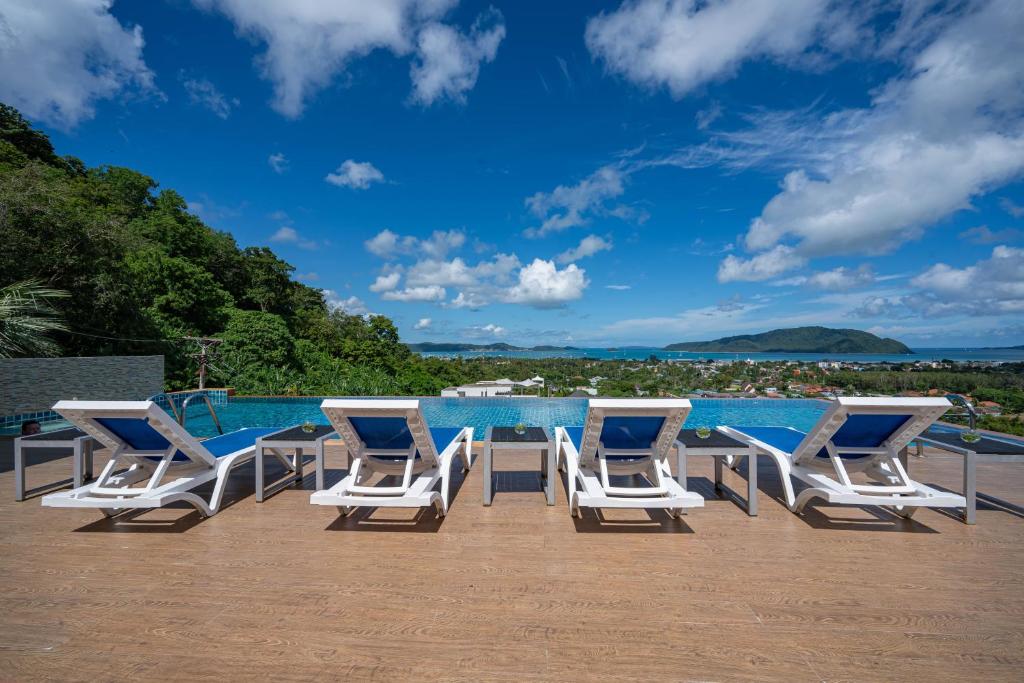 a group of chairs and a table on a deck at The View Rawada Phuket in Rawai Beach