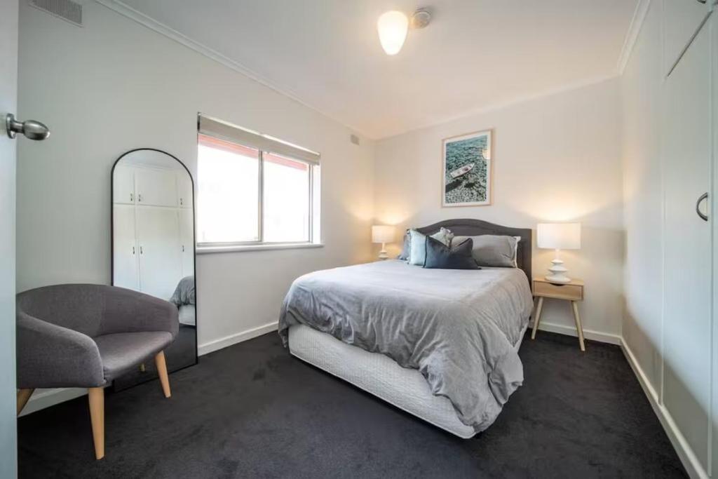 a bedroom with a bed and a chair and a window at Clouds on Francis - Cosy Comfort off Melbourne St in Bowden