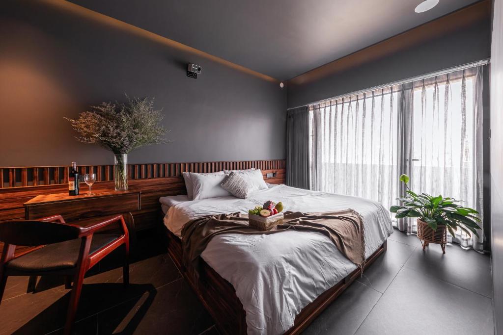a bedroom with a bed and a table and a window at ANZ Apartment in Tuy Hoa