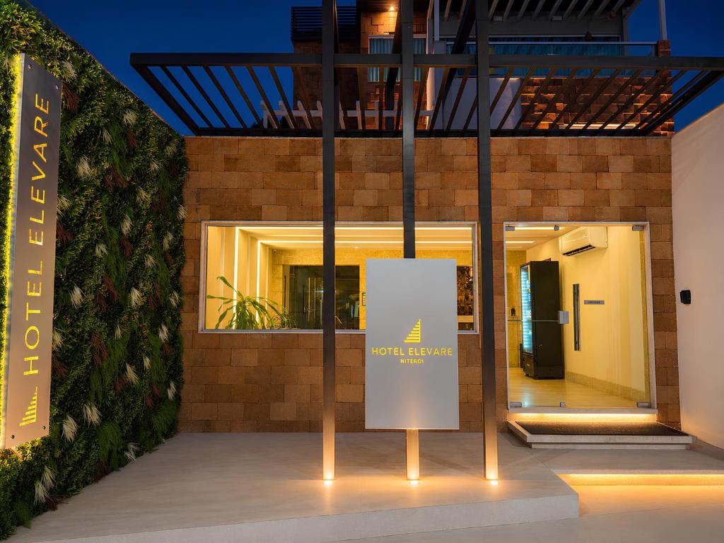 a sign in front of a building at night at Hotel Elevare Niteroi in Niterói