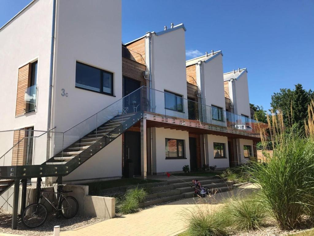 a white house with a staircase in front of it at Heilige-Hafen-Lodge in Heiligenhafen
