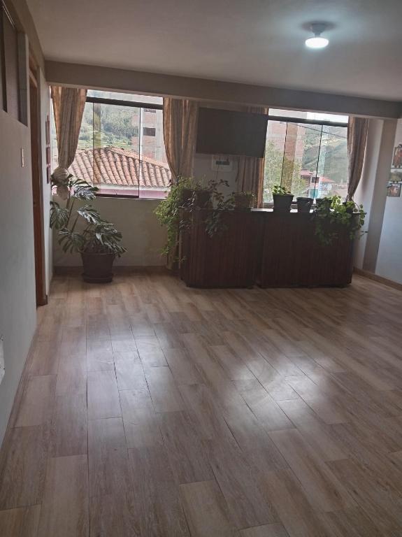an empty living room with potted plants on the floor at Hospedaje San Isidro in Cali