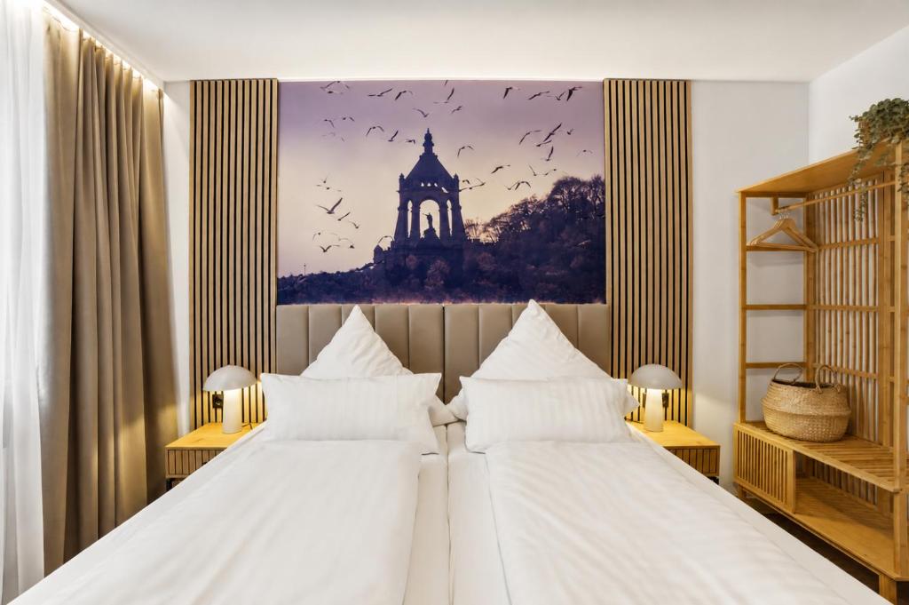 a bedroom with two beds and a picture of a tower at Colleen Apartments Wesertal in Porta Westfalica