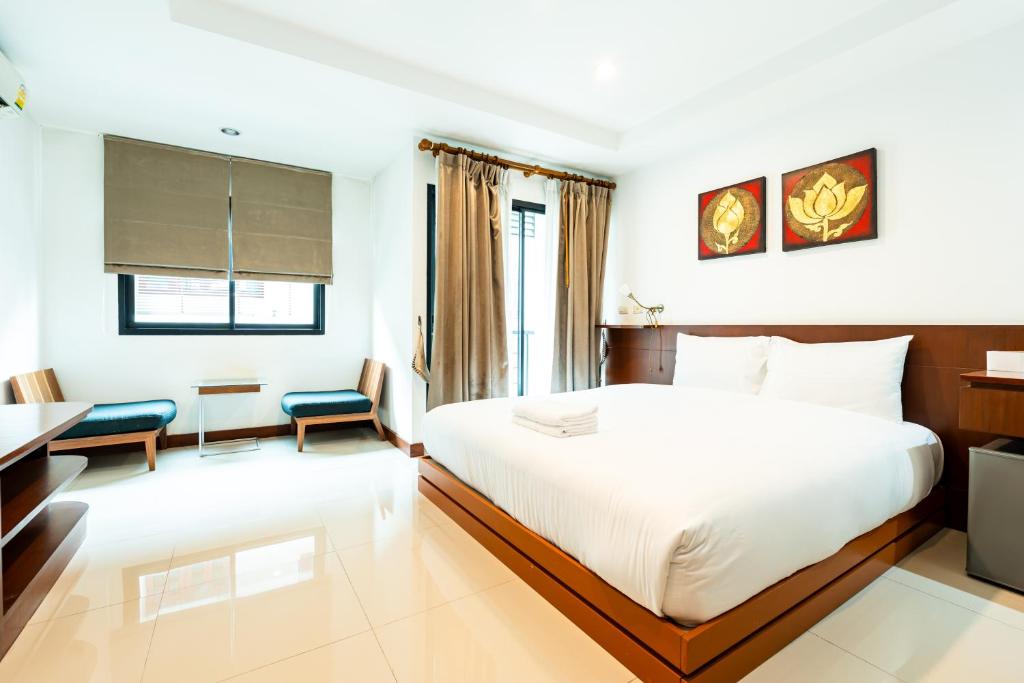 a hotel room with a white bed and a desk at XXYon INN Sukhumvit 4 - ยอน อินน์ 4 in Bang Kapi