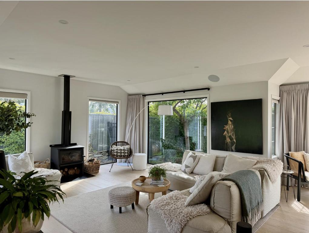 a living room with a white couch and a fireplace at The Orchard Escape - Cromwell in Cromwell