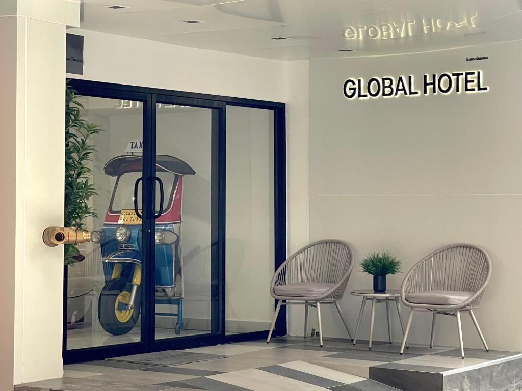 a lobby with two chairs and a glass door at Global Hotel Pratunam Bangkok in Bangkok