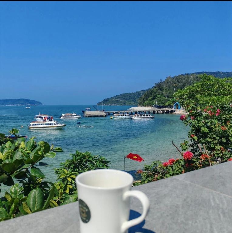 a coffee cup sitting on a ledge with a view of the water at Tuan Thanh Homestay in Tân Hiệp