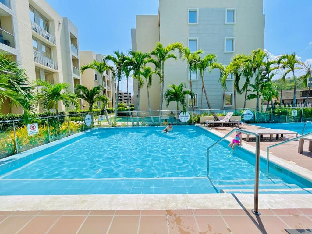 a swimming pool at a resort with palm trees at Capriela Serena del Mar in Cartagena de Indias