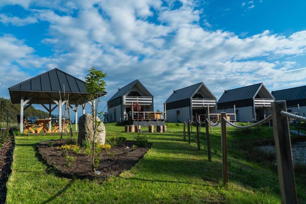 a group of houses in a field with grass at Nad brzozowym stawem in Kościerzyna