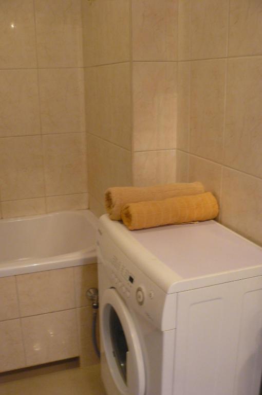 a white washing machine in a bathroom with a tub at Warsaw Center - Apartment near Central Railway Station in Warsaw