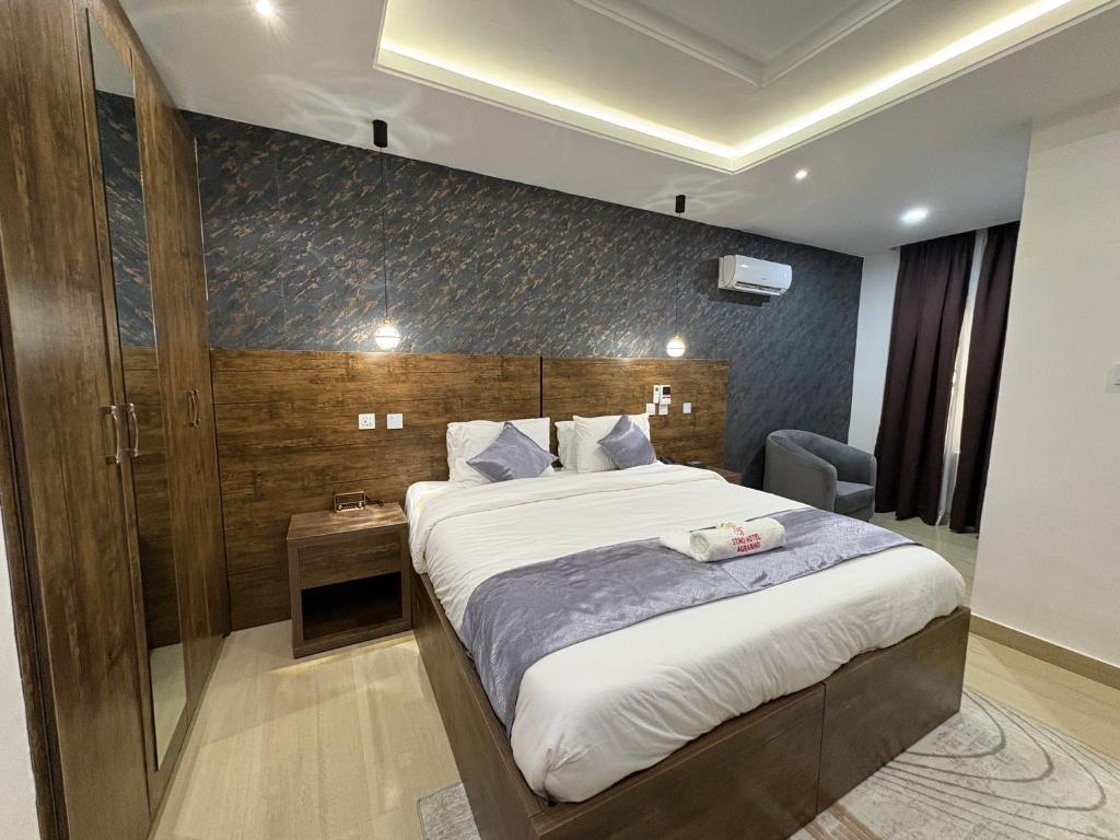 ein Hotelzimmer mit einem Bett und einem Stuhl in der Unterkunft Stino Hotel in Ogor