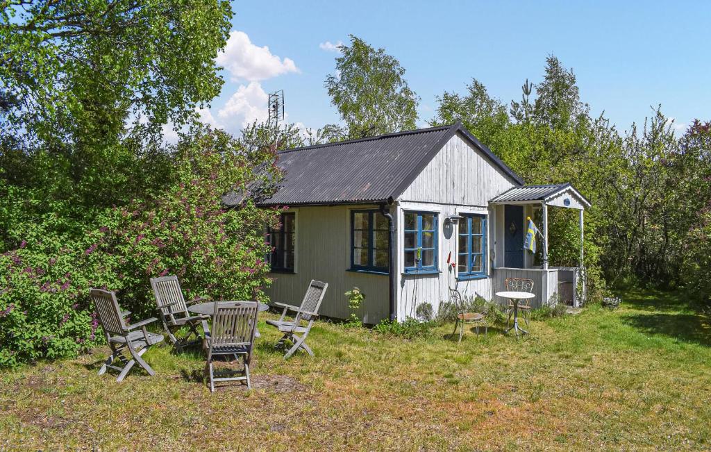 a small house with chairs and a table in the yard at Stunning Home In Borrby in Borrby