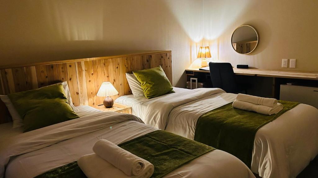 a hotel room with two beds and a desk at Loving Garden Stayラビングガーデンステイ in Mima