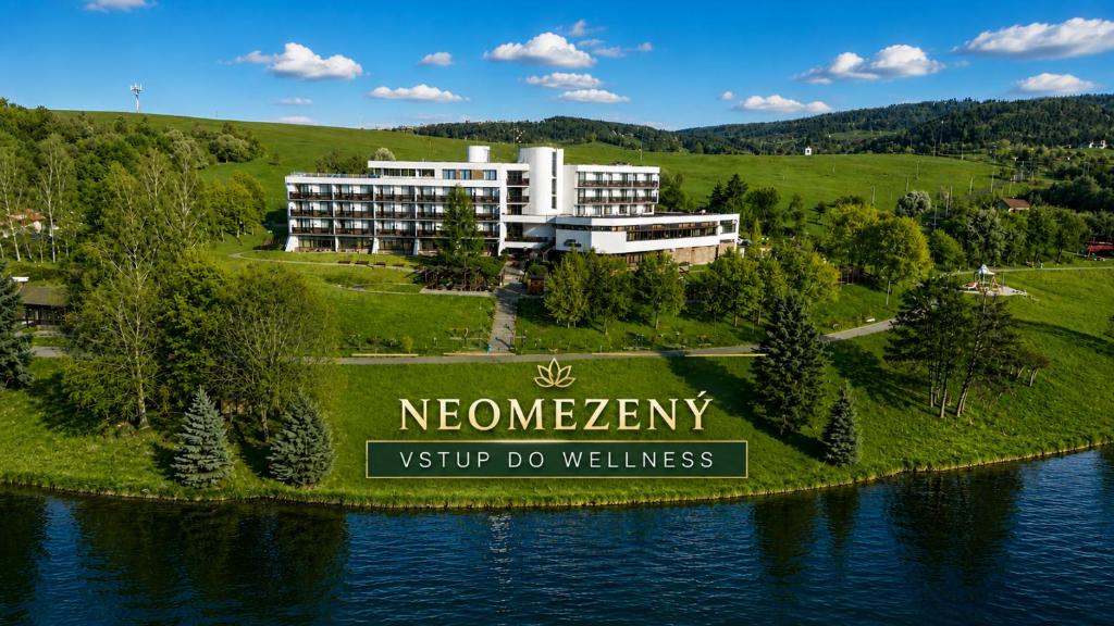 a hotel on an island in the water with a sign at Hotel Adamantino in Luhačovice