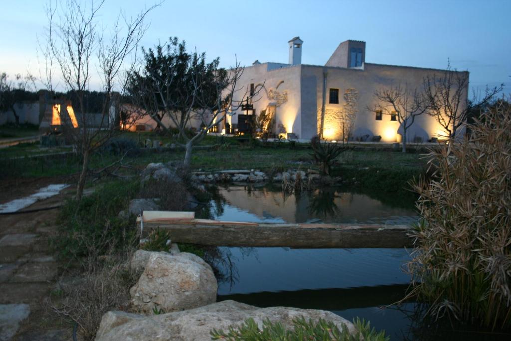 uma casa com um lago em frente em Masseria Mattiani em Campi Salentina