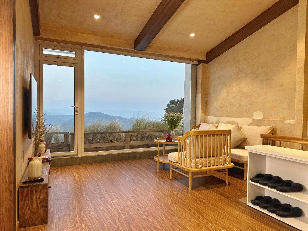a living room with a couch and a large window at Stardome Apartment Dalat in Ấp Ða Lợi