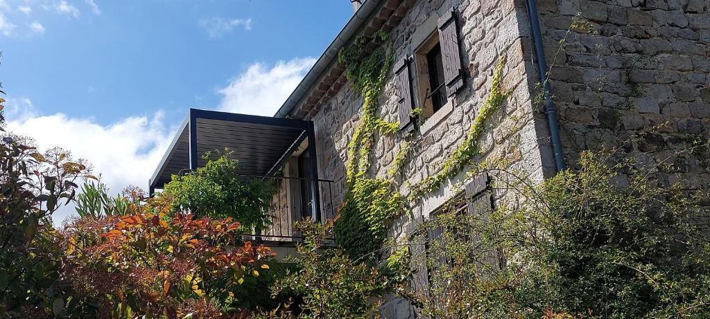 a brick building with a window and plants on it at Gîte de Laulagne in Ribes