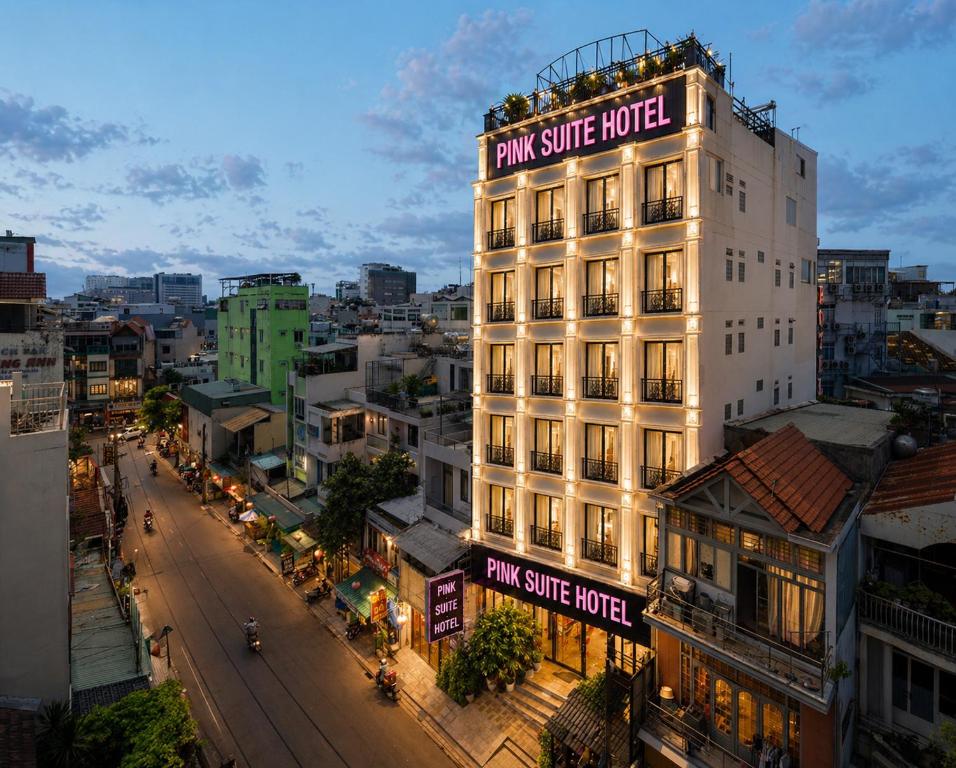 a tall white building with a pink supreme hotel on it at Pink Suite Saigon Airport Hotel in Ho Chi Minh City