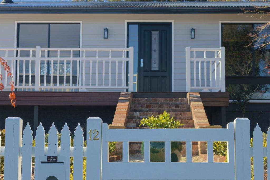 a white fence in front of a house at La Villa Dolce in Mount Victoria