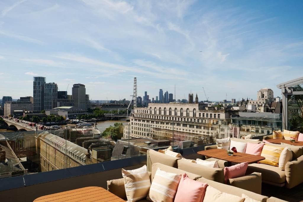 a view of a city skyline from a balcony with couches at ME by Meliá London - Covent Garden in London