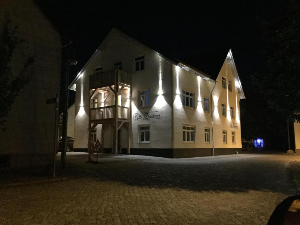 ein großes weißes Gebäude mit Lichtern in der Nacht in der Unterkunft Gästehaus Alte Bäckerei in Dachwig