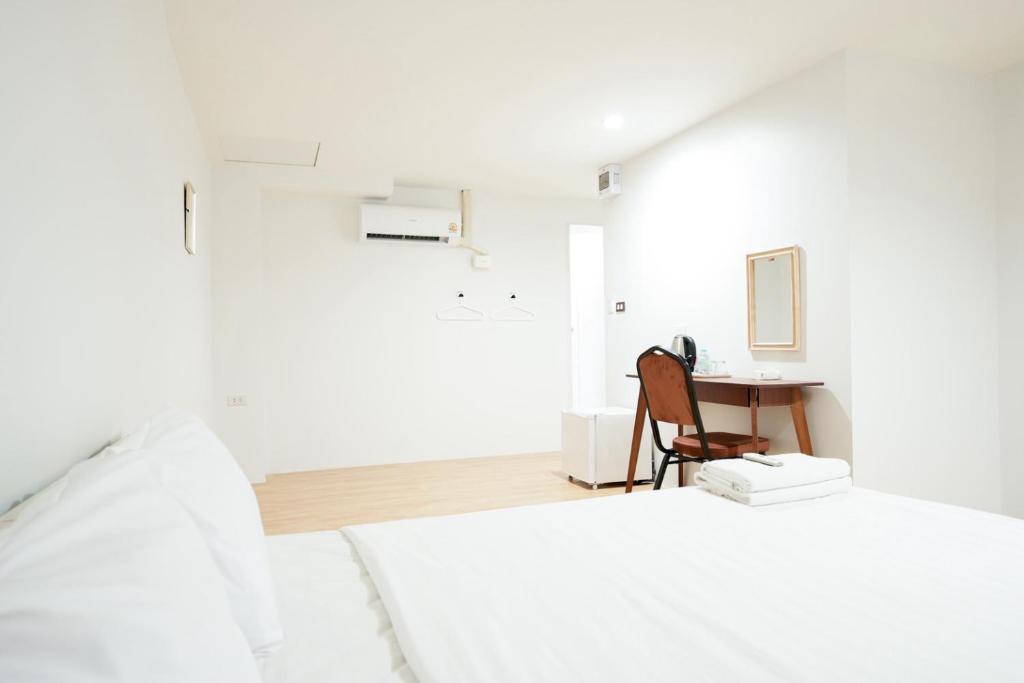 a white bedroom with a desk and a bed at Snap Sukhumvit 1 - BTS Nana in Makkasan